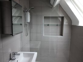 A bathroom with a sink and shower at Cornerhouse Apartment 4, Llandudno