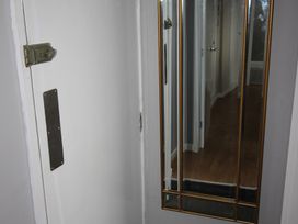 A hallway with a door and a mirror at Cornerhouse Apartment 4 in Llandudno