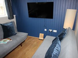 A living room with a television and two sofas at Cornerhouse Apartment 4 in Llandudno