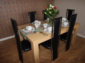 A dining room with a table set for meal at Cornerhouse Apartment 5 in Llandudno