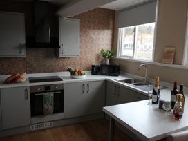 A kitchen with oven, sink, and table at Cornerhouse Apartment 5 in Llandudno