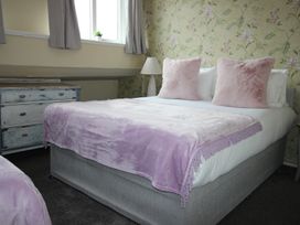 A bedroom with bed and dresser at Cornerhouse Apartment 5 in Llandudno