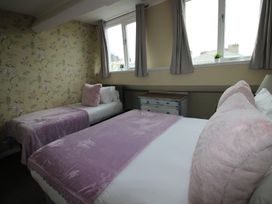 A bedroom with two beds and a dresser at Cornerhouse Apartment 5 in Llandudno