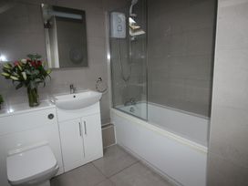 A bathroom with a shower, toilet, sink, and bathtub at Cornerhouse Apartment 5 Llandudno