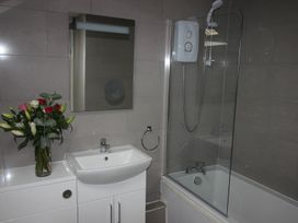 A bathroom with a shower and sink at Cornerhouse Apartment 5 Llandudno