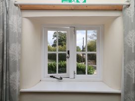 A window with a curtain and exit sign at The Cheese House near Charmouth