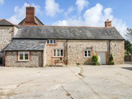 A cottage with a bench and flower pot at The Cheese House near Charmouth