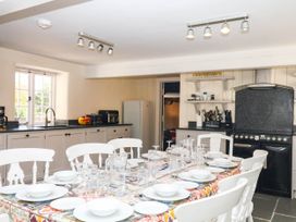A kitchen with a dining table and chairs at The Cheese House near Charmouth