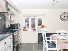 A kitchen with an oven, microwave, table and chairs at The Cheese House near Charmouth