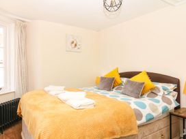 A bedroom with a bed and window at The Cheese House near Charmouth