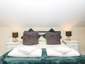 A bedroom with a bed and pillows at The Cheese House near Charmouth