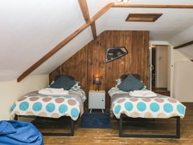 A bedroom with two single beds and a side table at The Cheese House near Charmouth