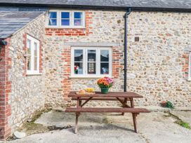 An outdoor area with a wooden table and flowers at The Cheese House near Charmouth