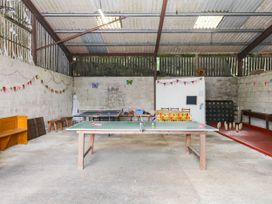A games room with a table tennis table and benches at The Cheese House near Charmouth