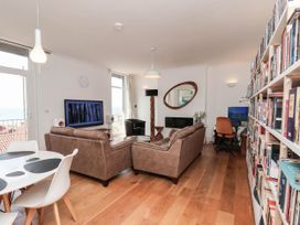 A living room with a television and a bookshelf at 26 Metropole Towers in Whitby