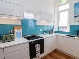 A kitchen with appliances and utensils at 26 Metropole Towers in Whitby