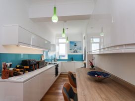 A kitchen with white cabinets and a wooden counter at 26 Metropole Towers in Whitby