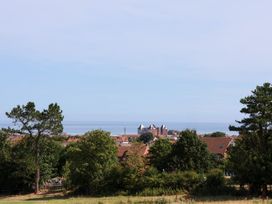 A view of houses and trees with the sea in the background at 26 Metropole Towers in Whitby