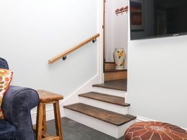 A staircase with a handrail and vase at Little Moorgate Okehampton