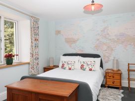 A bedroom with a bed and a world map on the wall at Little Moorgate Okehampton
