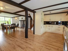 A kitchen with dining area and staircase at Honey Bee Cottage in Menheniot