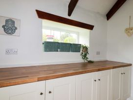 A kitchen with countertop and storage baskets at Honey Bee Cottage in Menheniot