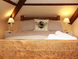 A bedroom with a bed and two bedside lamps at Honey Bee Cottage in Menheniot