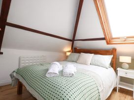 A bedroom with a bed and nightstand at Honey Bee Cottage in Menheniot