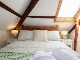 A bedroom with a bed and lamp at Honey Bee Cottage in Menheniot