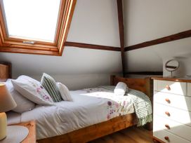 A bedroom with a bed and dresser at Honey Bee Cottage in Menheniot