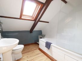 A bathroom with a sink and bathtub at Honey Bee Cottage in Menheniot