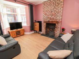 A living room with a television and a fireplace at Portobell House in Bridlington