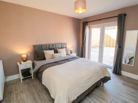 A bedroom with a bed and sliding doors to an outdoor area at Portobell House in Bridlington