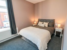 A bedroom with a bed and bedside tables at Portobell House in Bridlington