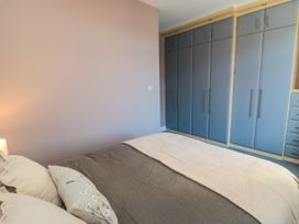 A bedroom with a bed and storage unit at Portobell House in Bridlington
