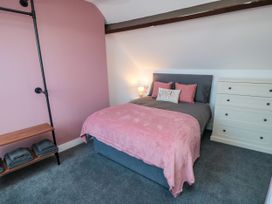 A bedroom with a bed and dresser at Portobell House in Bridlington