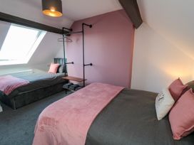 A bedroom with two beds and a hanging rack at Portobell House in Bridlington