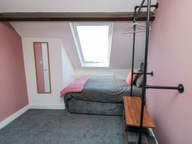 A bedroom with a bed and a mirror at Portobell House in Bridlington