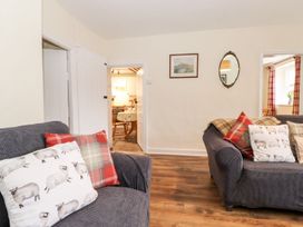 A living room with sofas and a doorway leading to another space at Irt Cottage Seascale