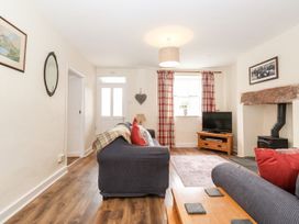 A living room with a sofa and television at Irt Cottage in Seascale