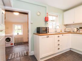 A kitchen with appliances and a washing machine at Irt Cottage Seascale