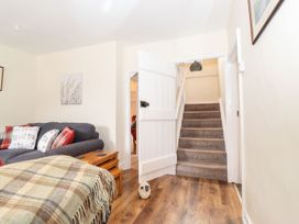 A living room with a sofa and a staircase at Irt Cottage in Seascale