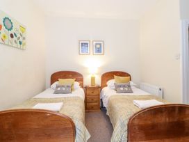 A bedroom with two single beds and a lamp at Irt Cottage in Seascale