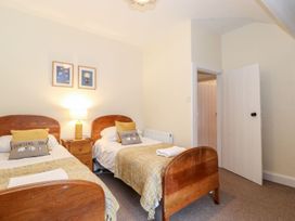 A bedroom with two beds and a lamp at Irt Cottage Seascale