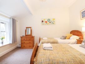 A bedroom with twin beds and a dressing table at Irt Cottage in Seascale
