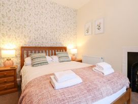 A bedroom with a bed and bedside tables at Irt Cottage Seascale