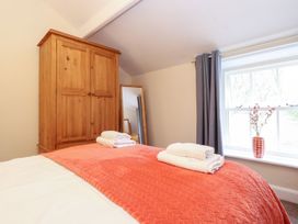 A bedroom with a wardrobe and mirror at Irt Cottage in Seascale