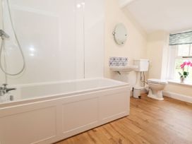 A bathroom with bathtub, toilet, sink and window at Irt Cottage in Seascale
