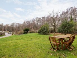 A garden with wooden table and chairs at Irt Cottage Seascale