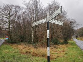 A road signpost with directions in a wooded area at Irt Cottage Seascale